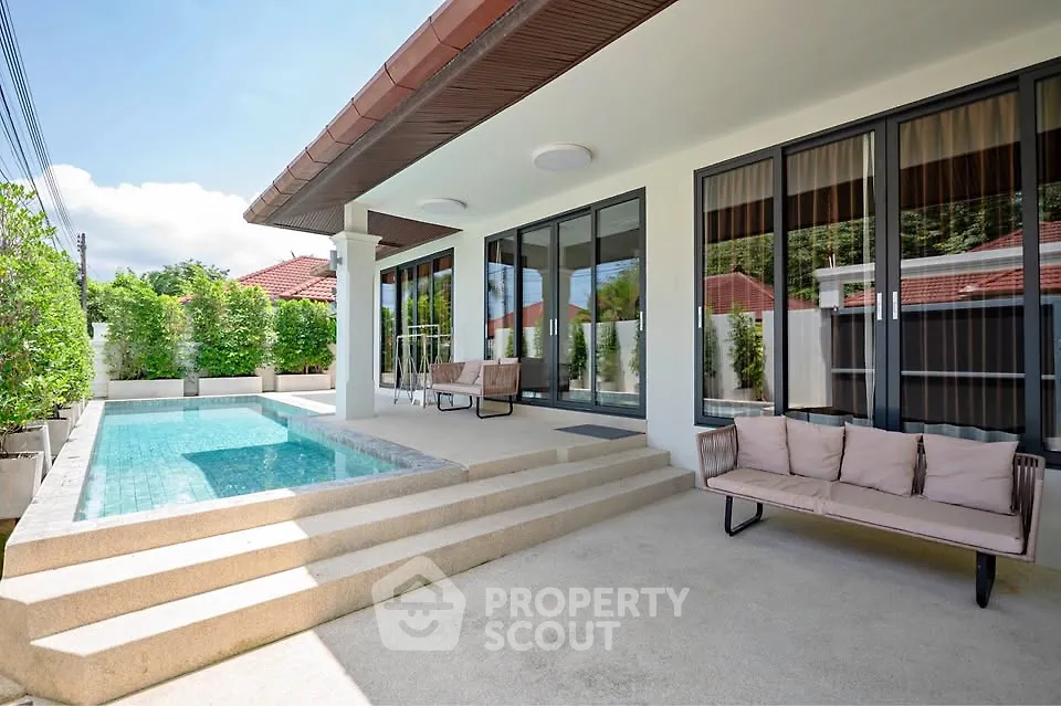 Luxurious modern home with private pool and stylish patio seating, perfect for relaxation.