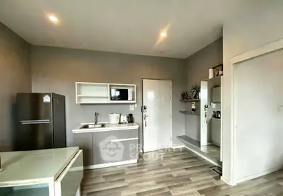 Modern kitchen with sleek cabinets, appliances, and stylish flooring in a contemporary apartment.