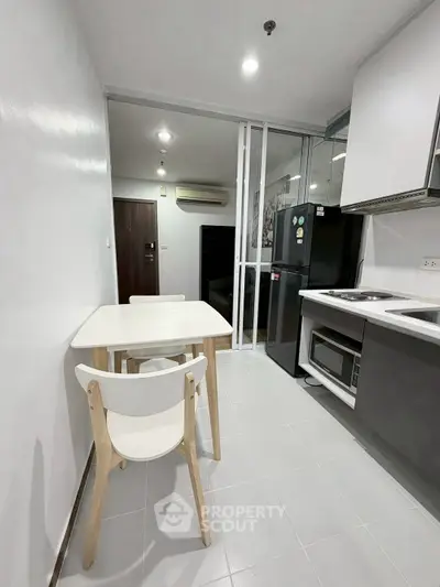 Modern kitchen with sleek appliances and dining area in a compact layout