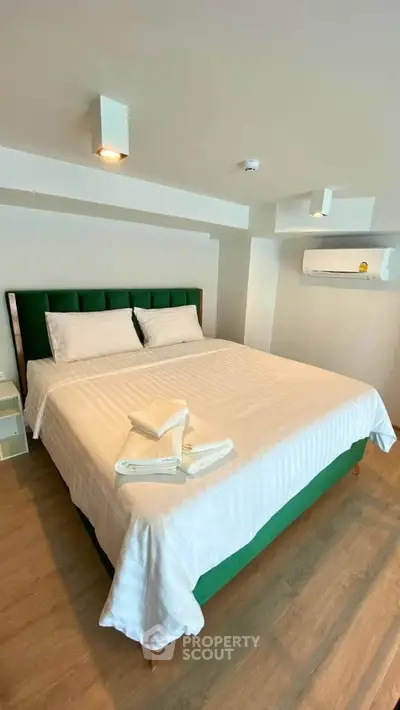 Spacious bedroom with modern decor and air conditioning in a stylish apartment.