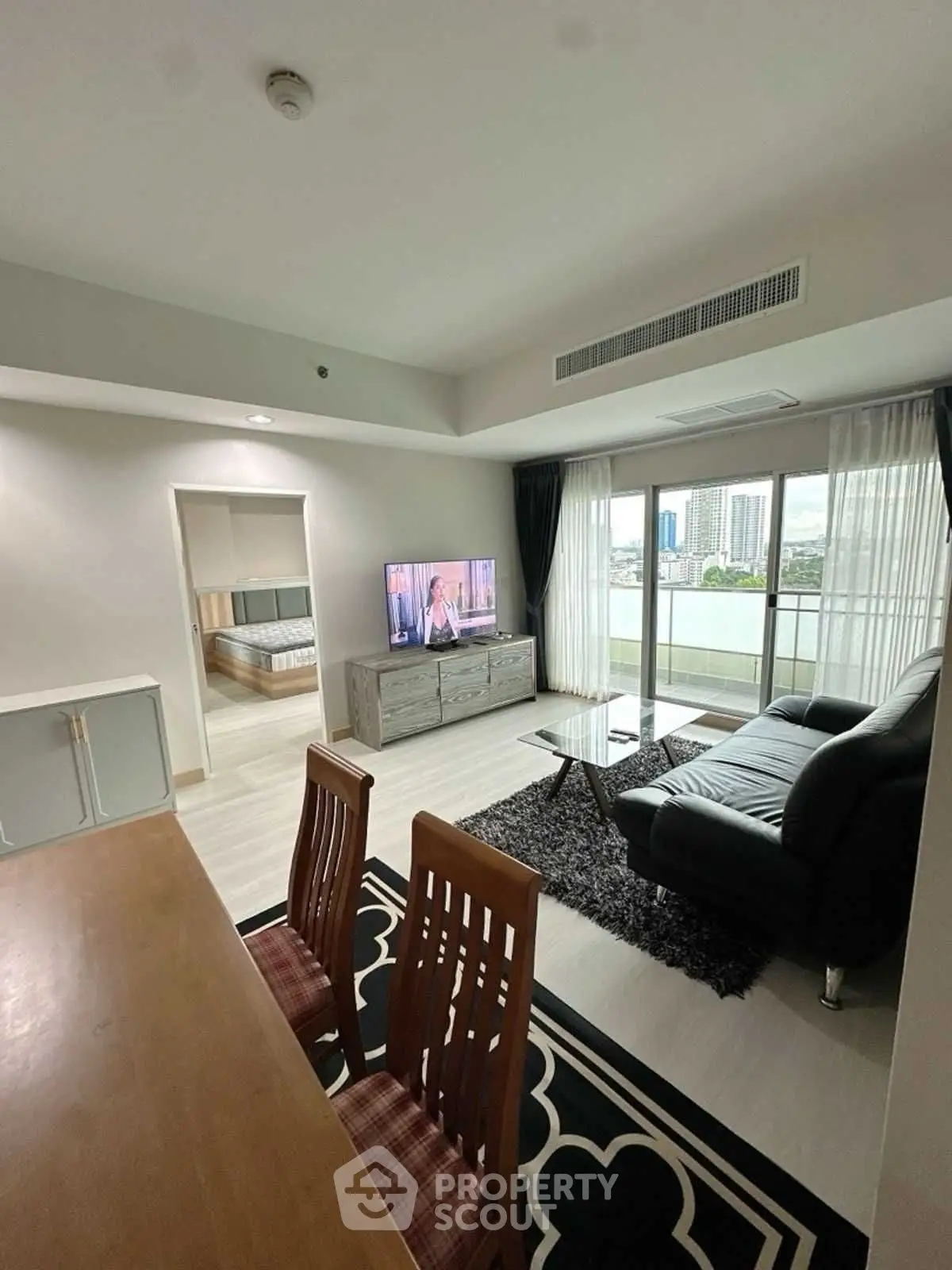 Modern living room with sleek furniture and city view from large windows