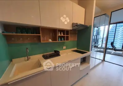 Modern kitchen with sleek cabinetry and open layout, featuring a city view through glass doors.