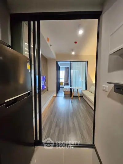 Modern apartment interior with open living room and kitchen, featuring sleek design and natural light.