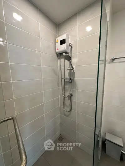 Modern bathroom with sleek shower and tiled walls in a contemporary home.