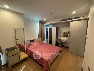 Spacious bedroom with modern furnishings and wooden flooring, featuring a cozy bed and ample storage space.