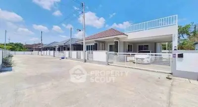 Modern single-story homes with spacious driveways and clear blue skies.
