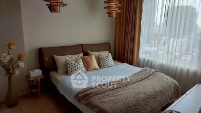 Luxurious bedroom with modern decor and city view, featuring elegant lighting and cozy bedding.