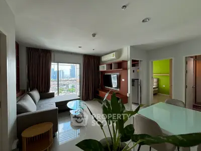 Modern living room with city view, stylish furniture, and natural light.