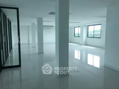 Spacious open-plan office space with large windows and glass partitions.