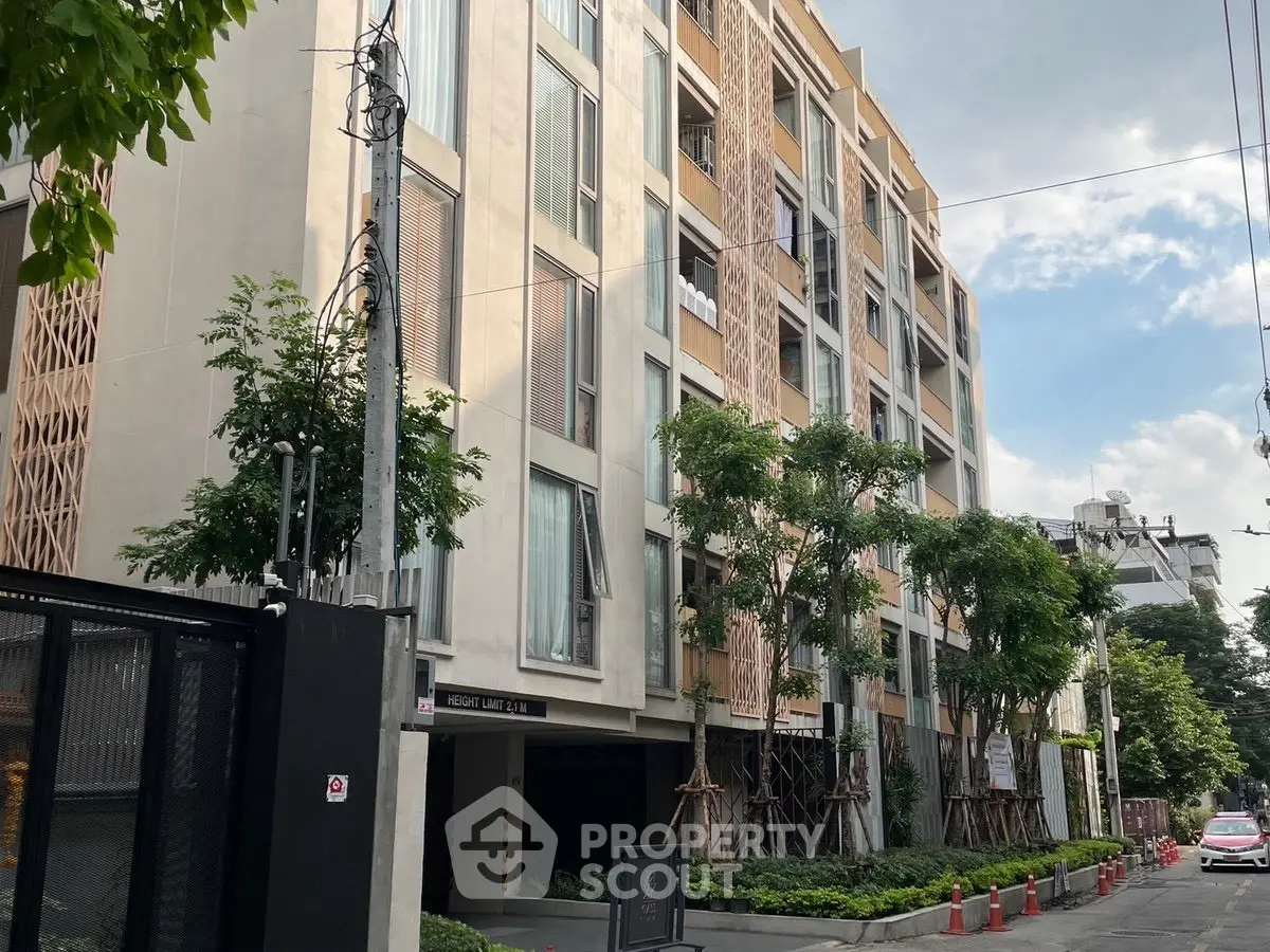 Modern apartment building with lush greenery and contemporary design in urban setting.