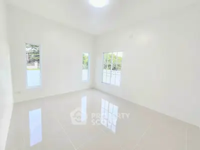 Spacious and bright empty room with large windows and glossy tiled floor.