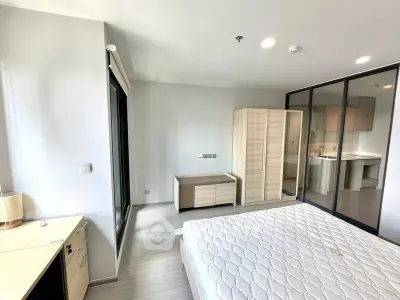 Modern bedroom with large windows and sleek furniture in a contemporary apartment.