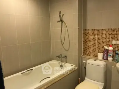 Modern bathroom with bathtub and tiled walls in a stylish apartment.