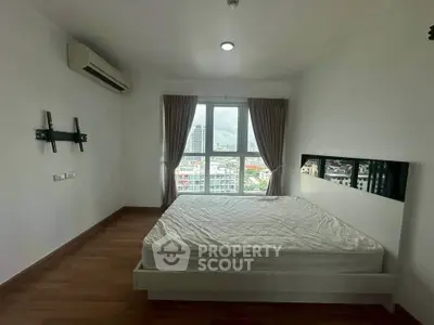 Spacious bedroom with city view, featuring a large window and modern minimalist design.