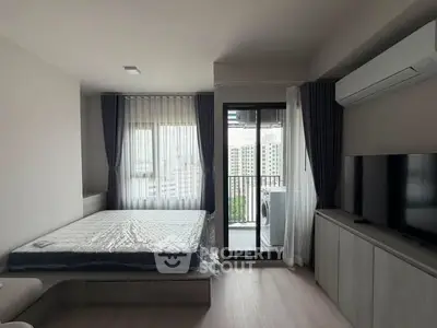 Modern bedroom with balcony access and city view, featuring a sleek design and natural light.