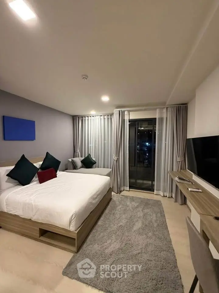 Modern bedroom with balcony access, featuring stylish decor and cozy ambiance.