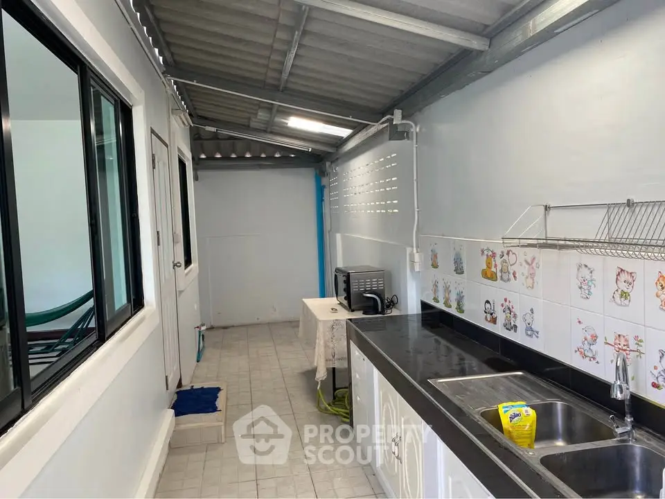 Charming kitchen with open layout and playful tile accents, featuring modern appliances and ample counter space.
