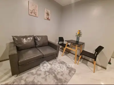 Cozy living room with modern sofa and dining set, perfect for small spaces.