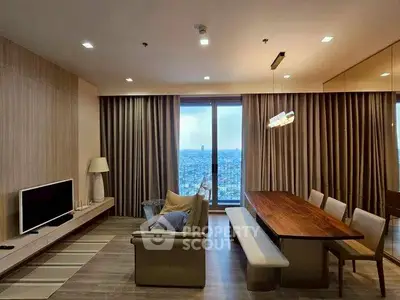 Modern living room with city view, featuring elegant dining area and cozy seating.