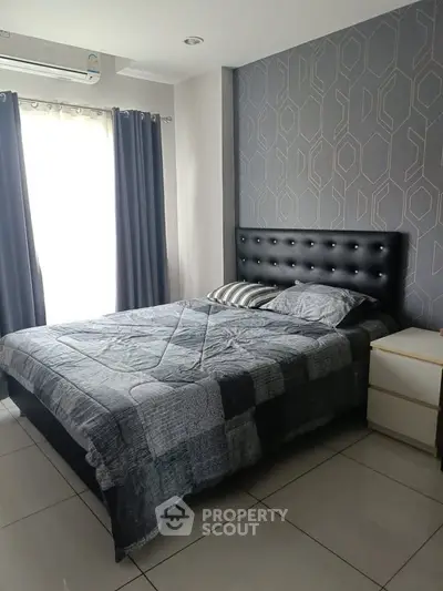 Modern bedroom with stylish decor and natural light, featuring a comfortable bed and elegant wallpaper.