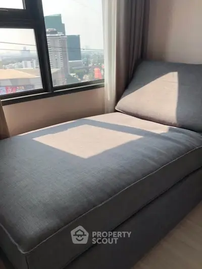 Cozy bedroom with a large window offering a stunning city view, perfect for relaxation and comfort.