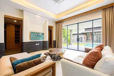 Luxurious living room with pool view and modern decor in a spacious home.