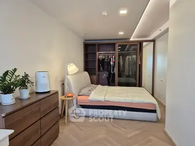 Spacious modern bedroom with stylish furniture and walk-in closet