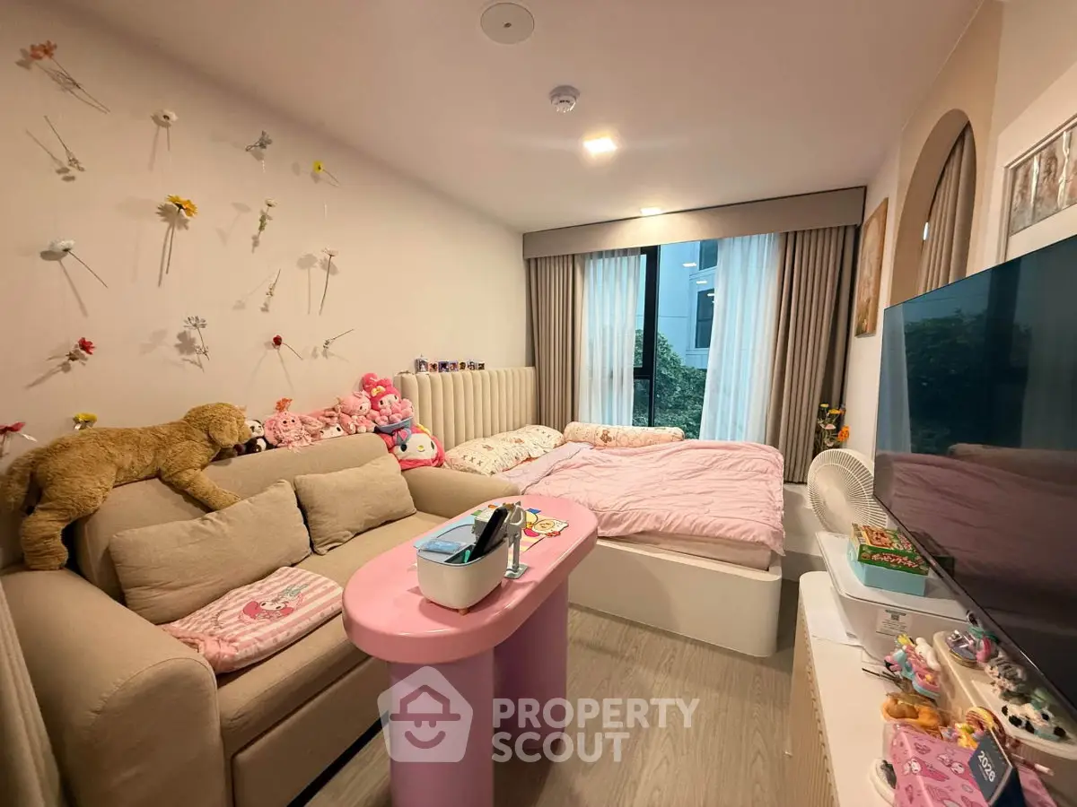 Charming living room with cozy sofa, playful decor, and large window for natural light.