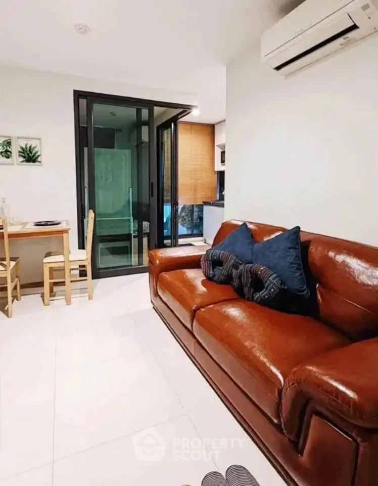 Modern living room with leather sofa and dining area in stylish apartment