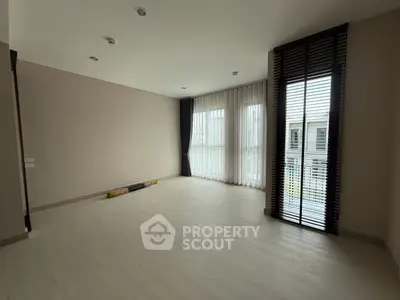 Spacious empty room with large windows and modern blinds, perfect for customization.