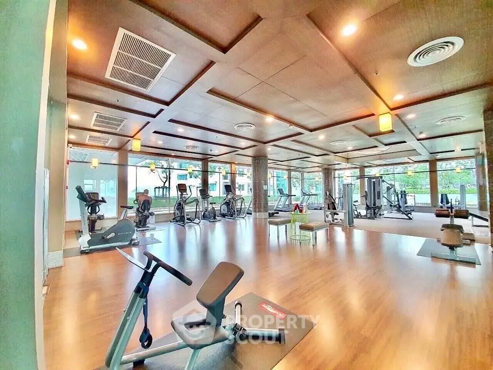 Spacious modern gym with state-of-the-art equipment and large windows for natural light.