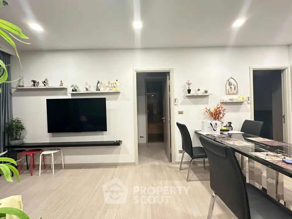 Modern living room with sleek TV setup and elegant dining area, perfect for contemporary living.