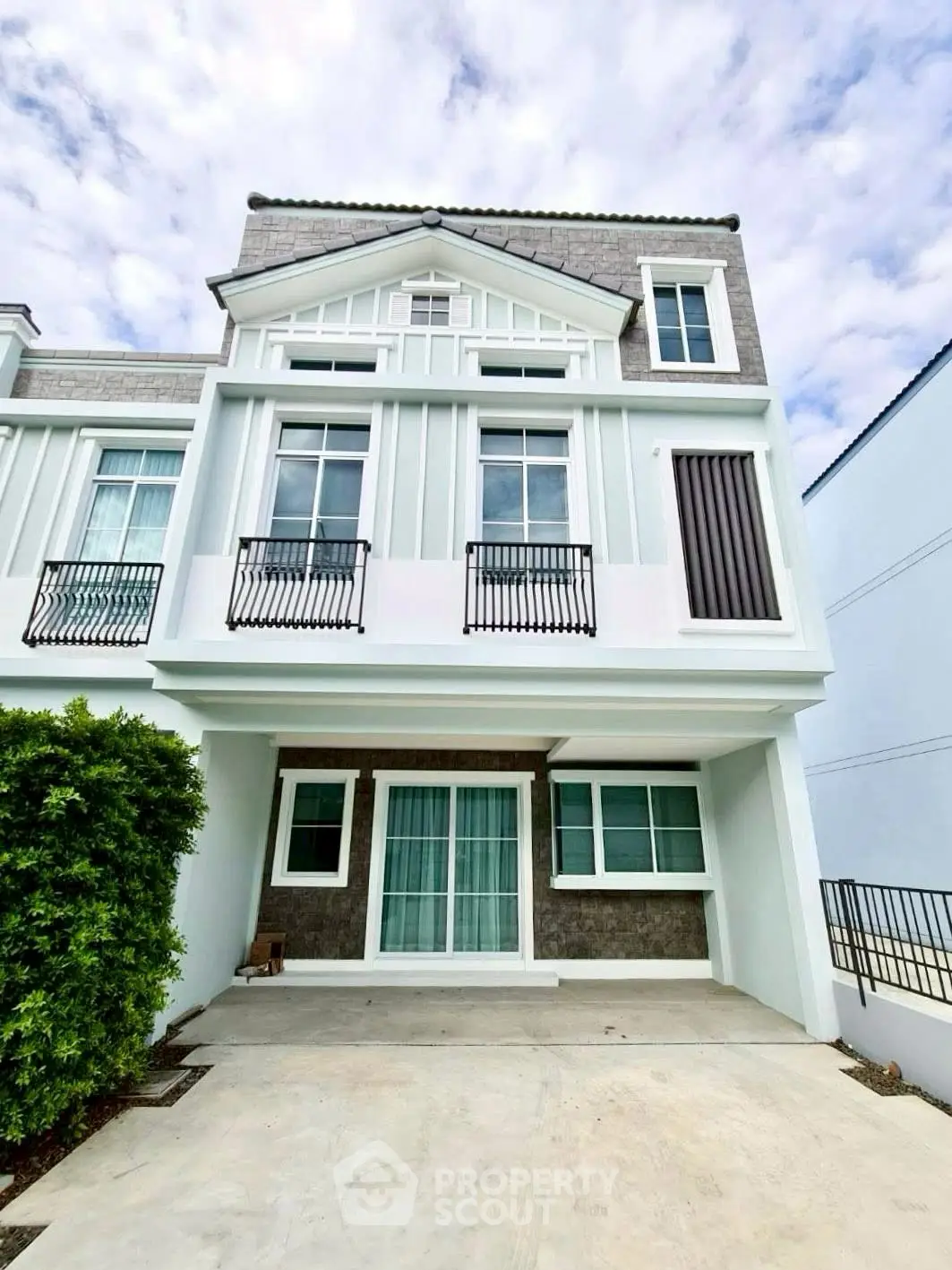 Charming multi-story house with elegant facade and lush greenery, perfect for family living.
