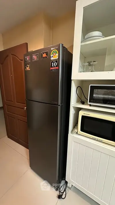 Modern kitchen with sleek fridge and microwave in cozy apartment