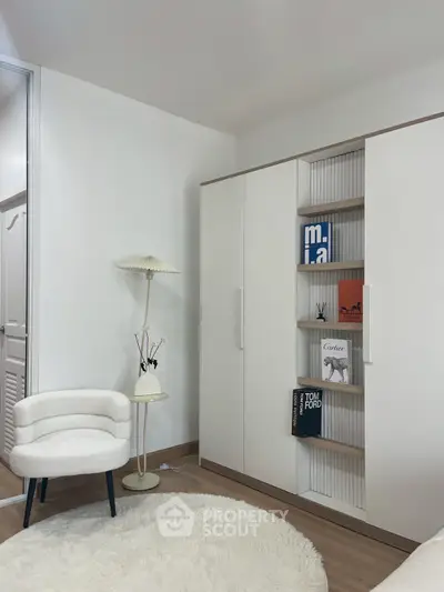 Modern bedroom with stylish white wardrobe and cozy chair