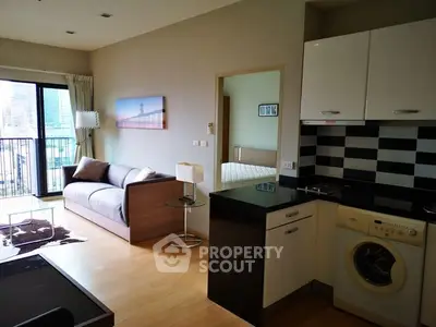 Modern apartment with open layout, featuring a cozy living area and compact kitchen.