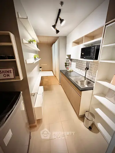 Modern kitchen with sleek design, featuring open shelving and built-in microwave for efficient space use.
