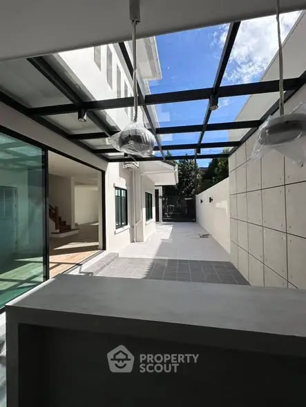 Modern home with glass ceiling and spacious outdoor area, perfect for entertaining.
