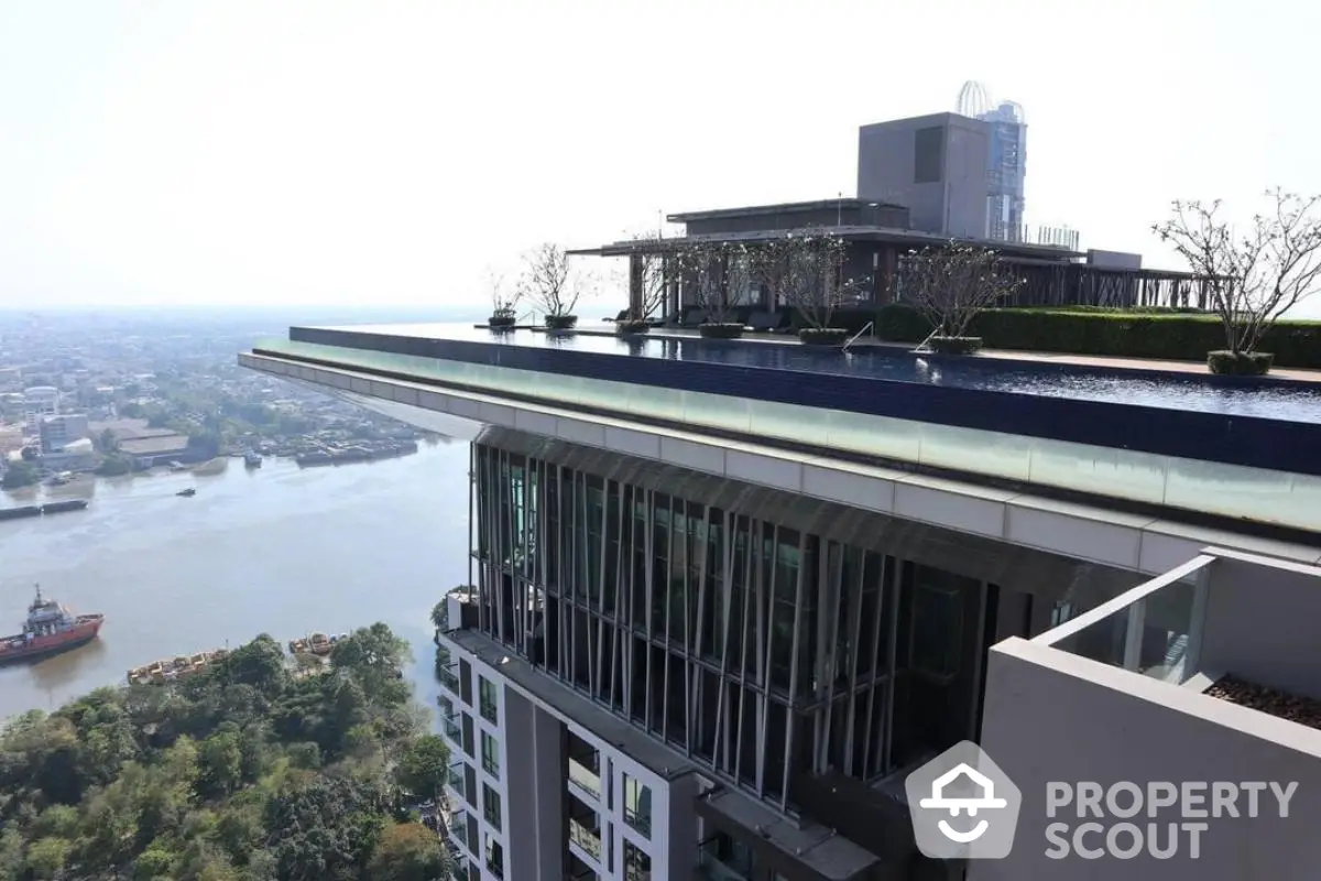 Stunning rooftop pool with panoramic city and river views in luxury high-rise building.