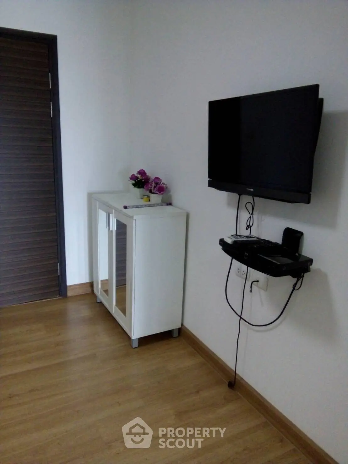 Modern minimalist living room with wall-mounted TV and sleek cabinet