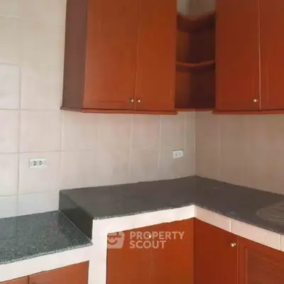 Spacious kitchen with elegant wooden cabinets and granite countertops