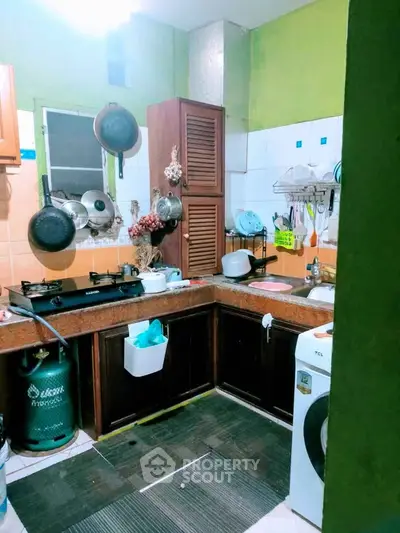 Cozy kitchen with gas stove and washing machine in a compact layout