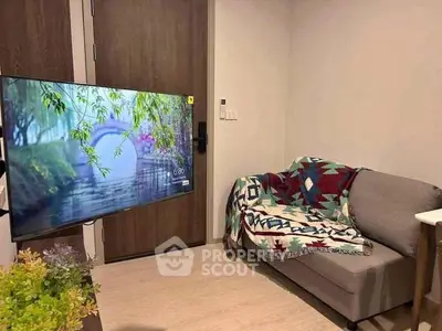 Cozy living room with modern TV and stylish sofa, perfect for relaxation.