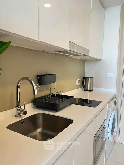Modern kitchen with sleek white cabinetry, built-in appliances, and minimalist design.
