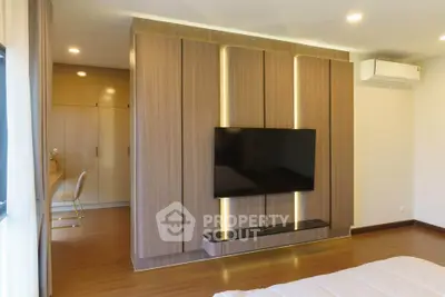 Modern bedroom with sleek TV wall unit and ambient lighting