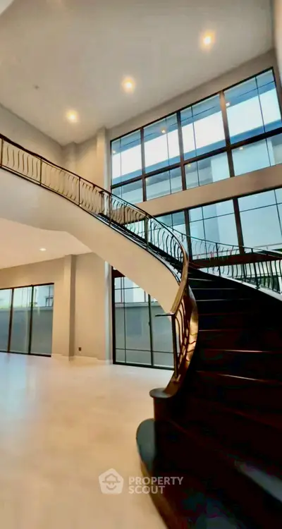 Luxurious modern staircase with elegant railing in spacious open-concept home.