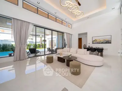 Luxurious modern living room with elegant decor and pool view, featuring a spacious open layout and stylish lighting.