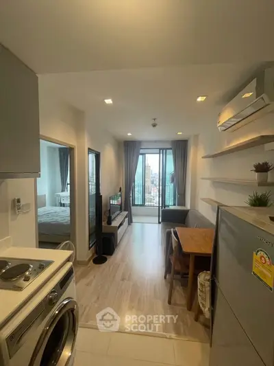Modern apartment interior with open layout, featuring kitchen, living area, and city view balcony.