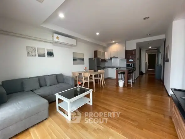Spacious open-plan living room with modern kitchen and wooden flooring