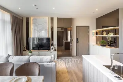 Luxurious modern living room with open kitchen, elegant decor, and natural light.